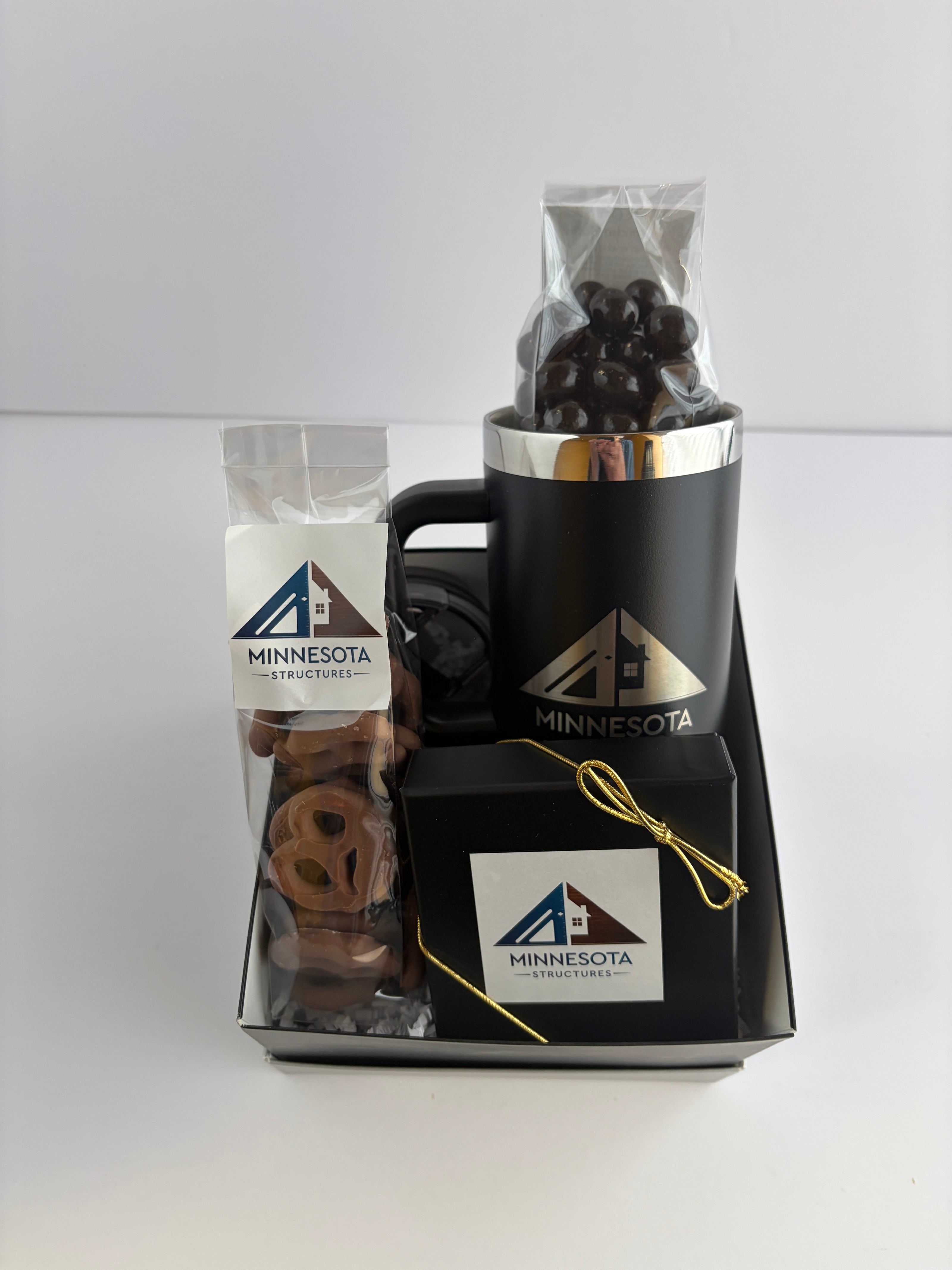 Custom Gift set with chocolate covered pretzels, chocolate covered espresso beans, and chocolate sea salt caramels all with their company logo on them in a large gift box. 
