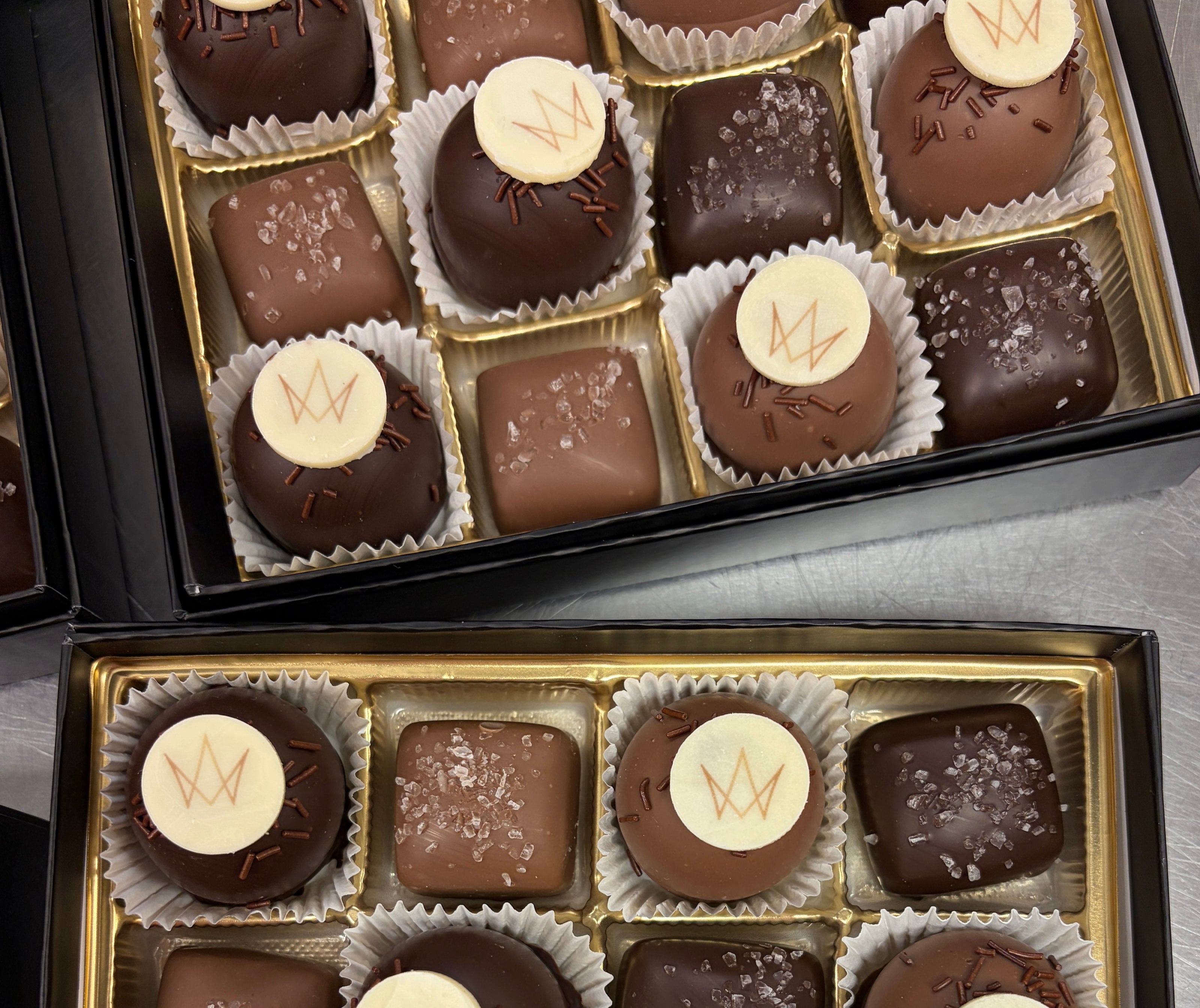 Assorted truffles and sea salt caramels in a box with a brand logo in a beautiful gift box.