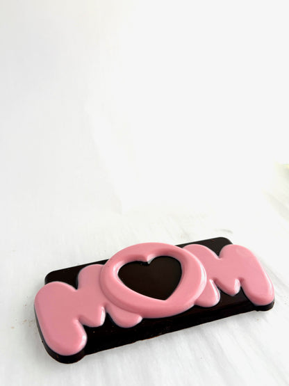Chocolate bar with 'MOM' text and heart design on a white background